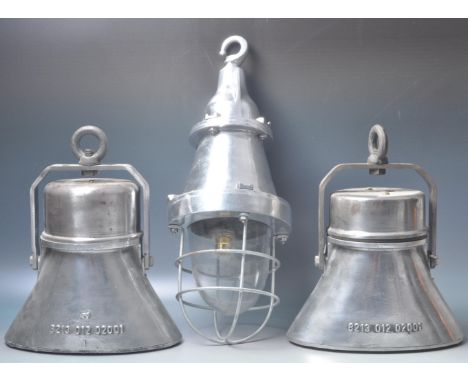 A group of late 20th century industrial aluminium light fittings to include a hanging bulkhead cage light and two other penda