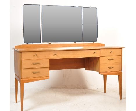 A vintage retro mid 20th century Alfred Cox teak dressing table. The dressing table having raised triptych mirror upon a base