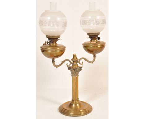 A Victorian 19th century twin head brass oil lamp having an etched globular shades on a classical column raised on a circular