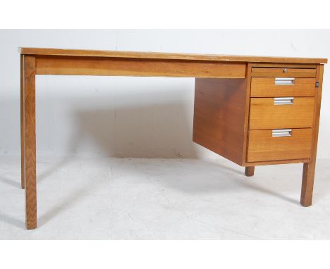 A retro vintage late 20th century teak desk having a bank of three drawers to the right with angular metal handles raised on 