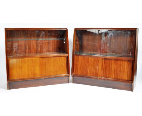 A matching pair of retro vintage mid 20th Century circa 1950's walnut low bookcase / display cabinets having twin sliding gla