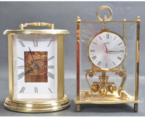 A 20th century 1990s Sewills brass cased carriage clock of oval form with reeded decoration to the sides, exposed movement an