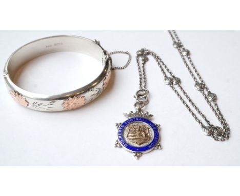 STERLING SILVER BANGLE
with overlaid rose gold decoration and safety chain; and an enamel decorated silver 'Mid-Herts Footbal