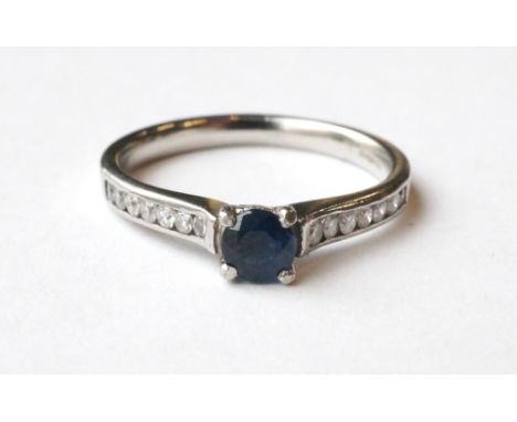 SAPPHIRE AND DIAMOND DRESS RING
the central round cut sapphire flanked by seven channel set diamonds to each shoulder, on pla