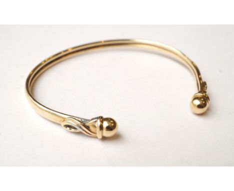 NINE CARAT GOLD BANGLE
with ball finials, approximately 5.3 grams