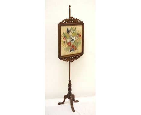VICTORIAN MAHOGANY POLE SCREEN
with a needlework and glazed panel with fret work carving, standing on three outswept supports