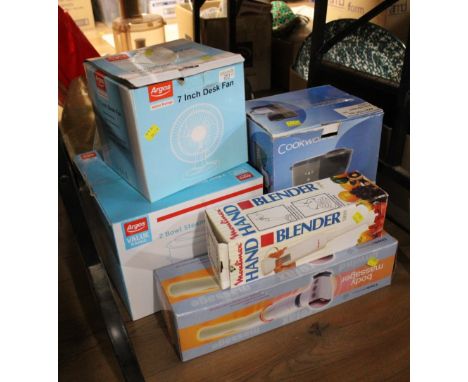 Boxed household accessories including desk fan, coffee maker, blender, body massager, steamer, fishing rod, lamp shade.
