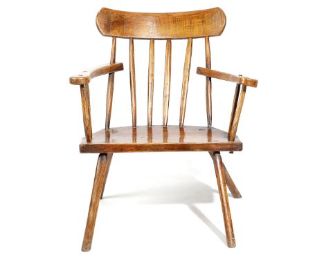 AN IRISH PRIMITIVE SYCAMORE AND ASH 'GIBSON' ARMCHAIR 19TH CENTURY the curved comb top rail above a stick back and a solid se