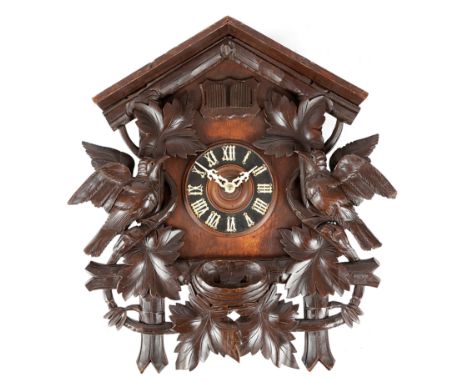 A BLACK FOREST LINDEN WOOD CUCKOO WALL CLOCK LATE 19TH CENTURY the brass eight day movement striking on a gong, with a 2in cy