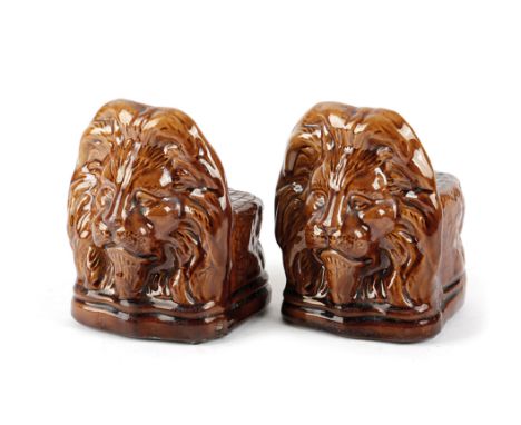 A PAIR OF POTTERY LION SASH WINDOW / FURNITURE RESTS 19TH CENTURY with a treacle glaze 13.3cm high Provenance Upper Slaughter