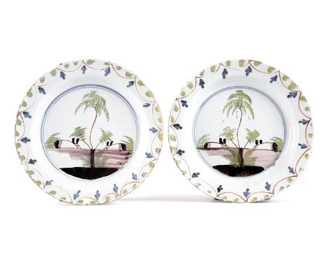 A PAIR OF DELFTWARE POTTERY PLATES LONDON, MID-18TH CENTURY each polychrome painted in green, blue and manganese with trees, 