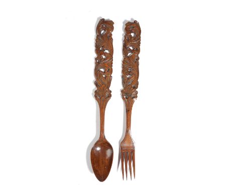 A TREEN YEW LOVE SPOON AND FORK WELSH, LATE 18TH CENTURY each handle carved with scrolling leaves (2) 33cm long Provenance Up