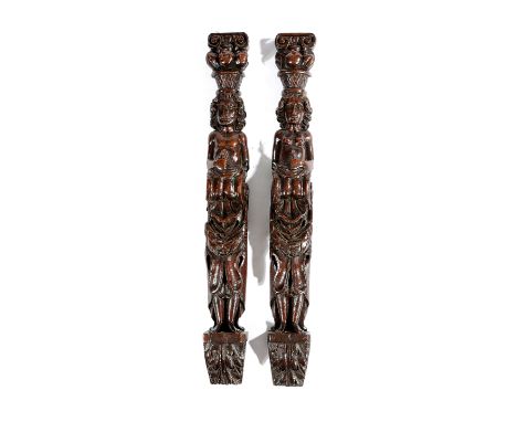 A PAIR OF OAK FIGURAL TERMS LATE 16TH / EARLY 17TH CENTURY each with a capital above a basket of fruit and with a semi-naked 