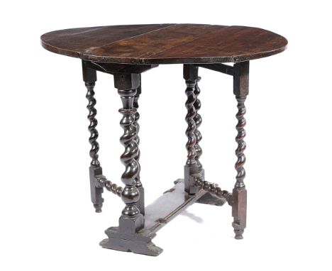 A SMALL CHARLES II OAK GATELEG TABLE C.1680 the oval drop-leaf top on turned spiral twist ends and gate supports, with scroll