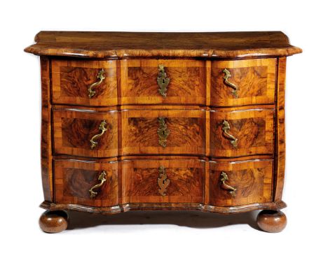 A GERMAN WALNUT SERPENTINE COMMODE 18TH CENTURY the quarter veneered and crossbanded top with a moulded edge, above three lon