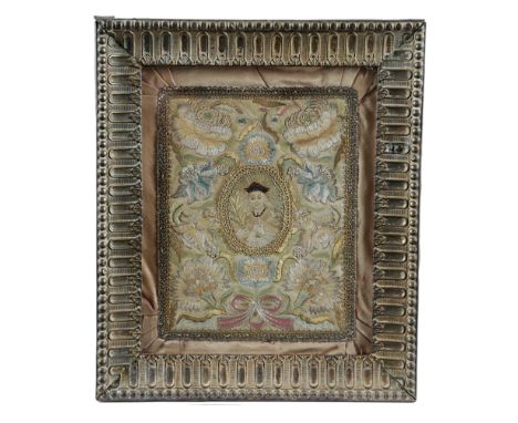 A NEEDLEWORK BOX COVER 18TH CENTURY worked in coloured silks and metal thread, with ribbon tied flowers around a central oval