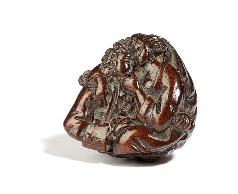 A TREEN SNUFF BOX AND COVER PROBABLY 18TH CENTURY of shell shape, the cover carved with an amorous couple 6.8cm wide Provenan