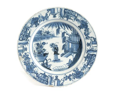 A DELFTWARE POTTERY CHARGER PROBABLY LIVERPOOL, MID-18TH CENTURY painted in blue in Chinese style with a lady holding a vase 