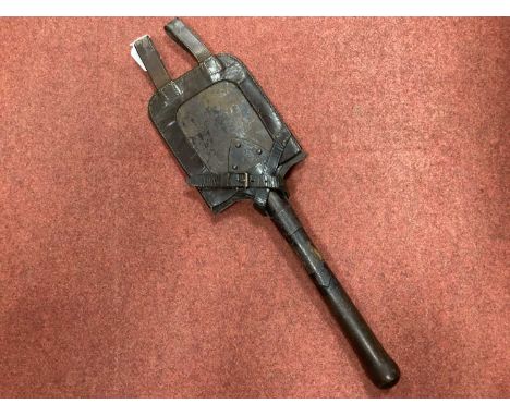 WW1 German entrenching tool with manufacturer mark and date 1915, complete with leather tool head cover and belt loop straps.