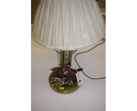 An Art Deco table lamp of hunting interest, the onyx base with silk shade, mounted by cold painted hollow cast hunt member on
