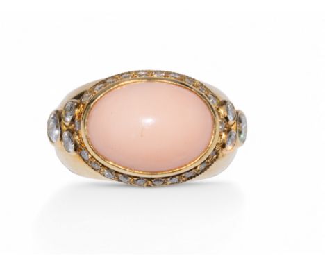Garrard, circa 1980s Angel skin coral, 18k gold and diamond ring. The oval shaped cabochon coral within a surround of small b