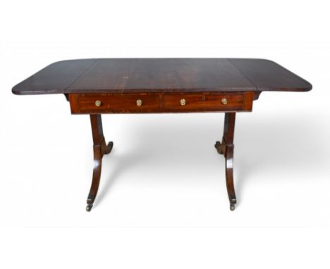 Regency A mahogany sofa table inlayed with ebonised lines The rectangular top with hinged sides Alternating real and false dr