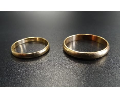 TWO GOLD WEDDING BANDSone in nine carat gold, ring size J-K and approximately 0.8 grams; the other with rubbed marks, ring si