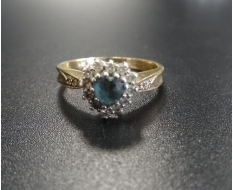 DIAMOND AND BLUE GEM SET CLUSTER RINGthe central heart cut blue gemstone in diamond surround and with further diamonds to the