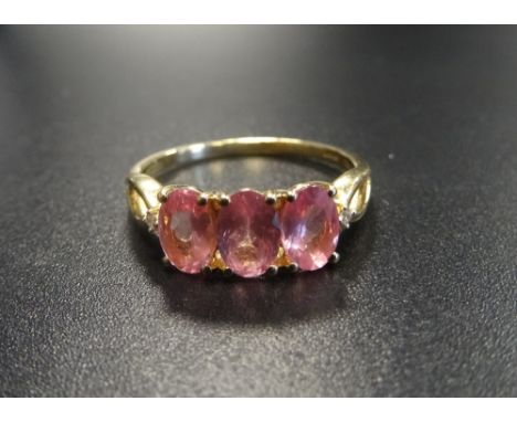 PINK SAPPHIRE AND DIAMOND RINGthe three oval cut sapphires flanked by small diamonds to the split shoulders, on ten carat gol