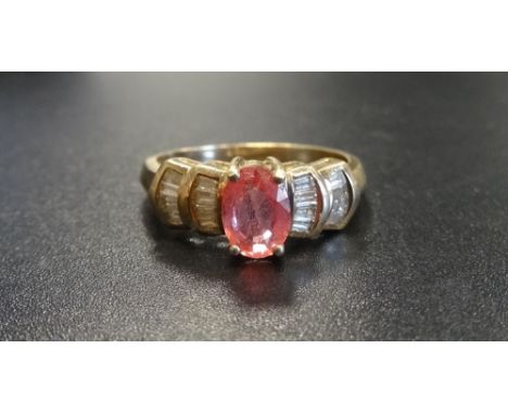 PINK GEM (POSSIBLY SAPPHIRE) AND DIAMOND DRESS RINGthe central oval cut pink gemstone flanked by baguette cut diamonds to the