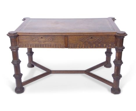 Late Victorian Gothic style oak writing table, the two drawers and frieze applied with a Gothic castellation design, with a g