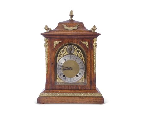 Late 19th century oak cased bracket clock, the case with applied floral metal mounts and a glazed door opening to a face with