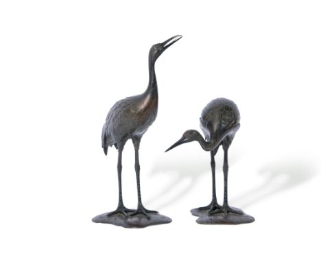 Pair of Japanese bronze cranes, Meiji period, standing on shaped bases, tallest 32cm high