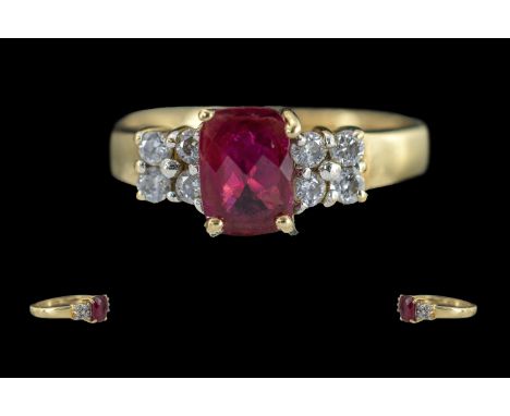 Ladies 9ct Gold Diamond and Ruby Set Dress Ring. Marked 9ct to Interior of Shank. The Central Faceted Ruby, Flanked by 8 Smal