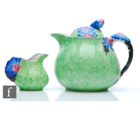 Clarice Cliff - Marguerite - A teapot and matched cream jug with relief moulded floral detail to the handles and finial picke