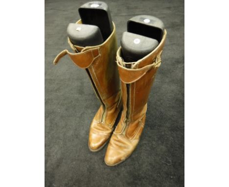 Two pairs of brown Polo boots, together with a pair of Hunting boots with tan tops and a further pair of riding boots
