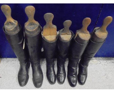 A pair of black and tan Hunting boots with wooden trees, together with two pairs of black riding boots, each with wooden tree