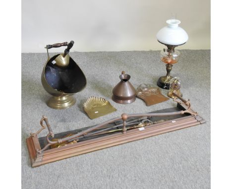 An early 20th century brass fender, together with fire tools, an oil lamp, a coal scuttle and an anniversary clock