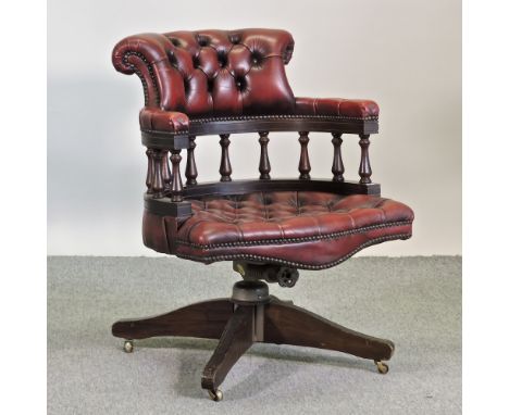 A red leather upholstered button back swivel desk chair