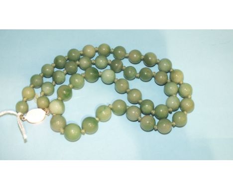 A string of jade coloured hardstone beads with silver clasp.