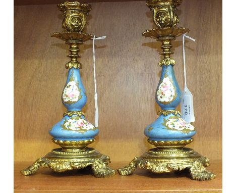 A pair of 19th century gilt metal and porcelain candlesticks, each gilt metal sconce and bottle-form ceramic column painted w