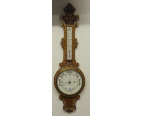Early 20th Century aneroid barometer and thermometer in carved oak case.