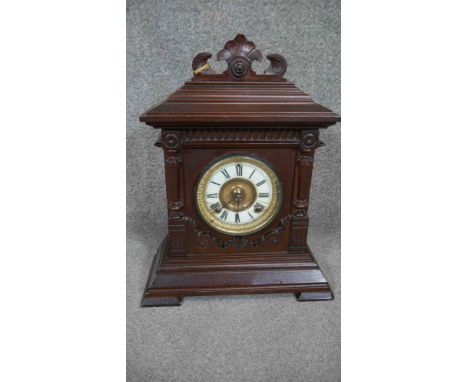 An American Ansonia carved mahogany mantle clock with white enamel dial, brass movement and pendulum.
H.43 W.34cm 
