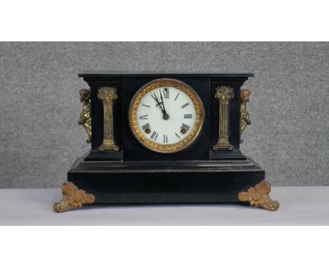 A C.1900 black slate mantle clock with figural ormolu detailing. Gilt metal column motifs to the front and a white enamel dia
