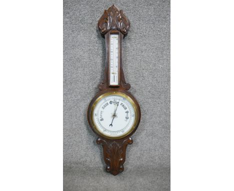 A late 19th century carved oak banjo barometer with white enamel dials and foliate design. H.84 W.26cm 