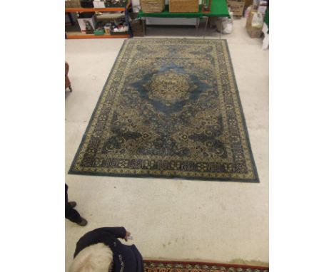 A machine made Persian style carpet in shades of blue, cream and mustard, 497 cm x 318 cm
