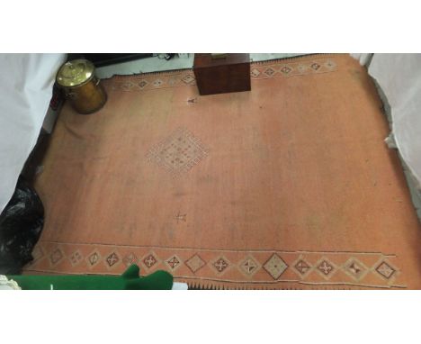 A Caucasian carpet, the central diamond shaped medallion in cream on a pale salmon ground within salmon, cream and burgundy d