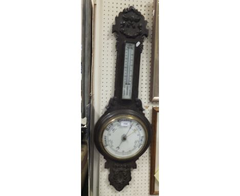 A mid 20th Century oak cased wall barometer / thermometer with carved acanthus and ribbon decoration
