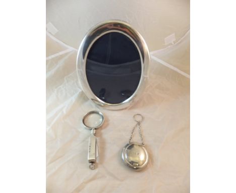 A modern silver photograph frame of oval form, a silver mounted magnifying glass and a silver patch box with gilt washed inte