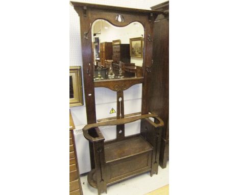 An early 20th Century Art Nouveau style oak hall stand with mirrored back and box seat, flanked by stick stands